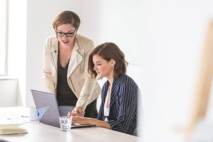 two women looking at a laptop