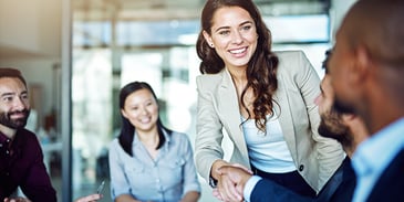 a woman shaking a clients hand smiling