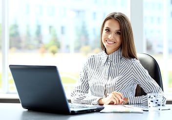 woman smiling in front of her laptop