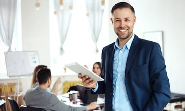 smiling man holding a tablet 