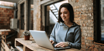 a smiling woman using laptop computer